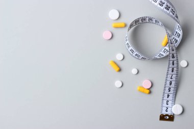 santimetre teyp ve metin için yer pastel bir zemin üzerine hap. kavram diyet, yağ ve kalori yakmak, kilo kaybı. Bioadditives.