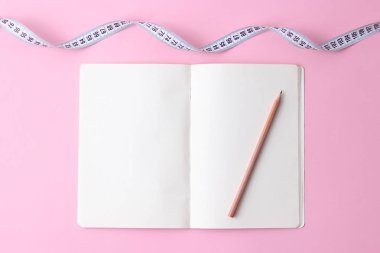 Not Defteri, kalem ve santimetre teyp pastel bir arka plan üzerinde metin için yer açın. kavramı, sağlık, sağlıklı beslenme, diyet, kilo kaybı. minimalizm. flatlay 