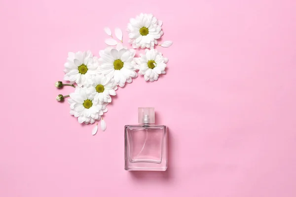 a bottle of perfume on a pastel background and a flower arrangement in the style of minimalism. Top view. floral fragrance. Flat lay