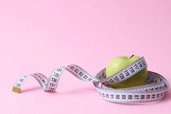 苹果和厘米带在彩色背景上 带有插入文字的地方 简约主义概念饮食 健康饮食 脂肪燃烧 卡路里 — 图库照片