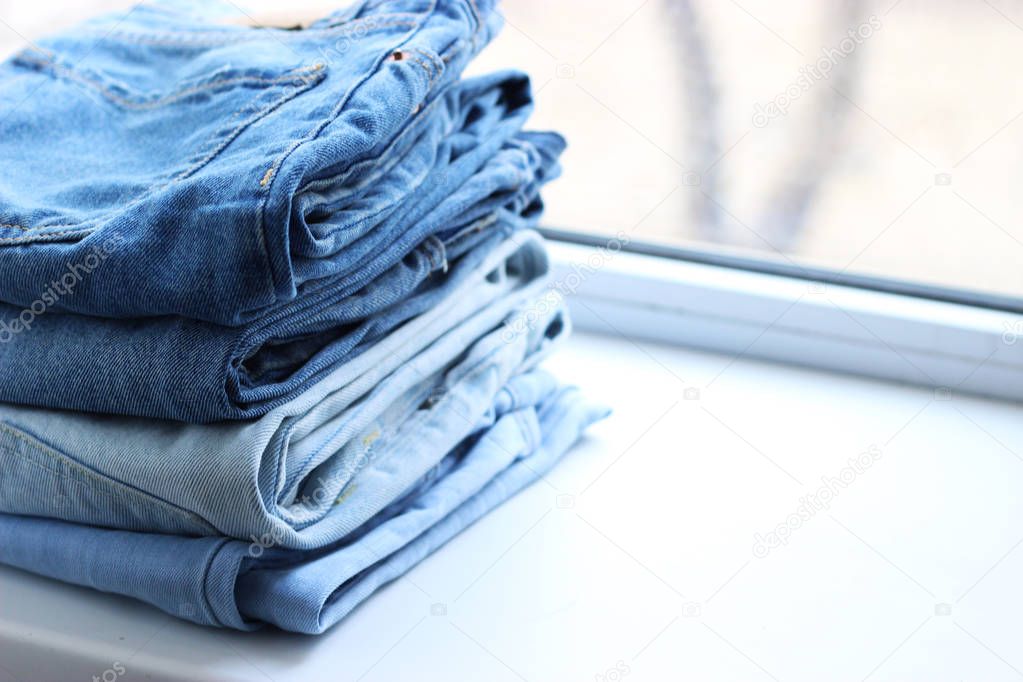 an ideal stack of jeans with a tag on the shelf of the store. a lot of folded jeans. jeans on the shelf.
