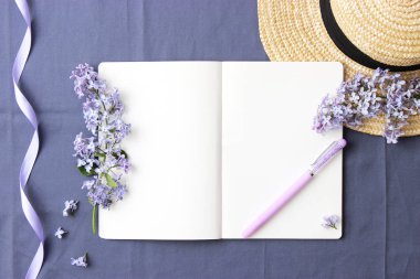 leylak ve dizüstü b hasır şapka yere metin eklemek için bir bez zemin üzerine. Minimalizm, üstten görünüm, çalışma alanı. yaratıcı latlay 