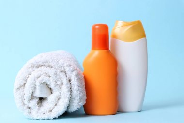 Güneş kremi, havlu, renkli bir arka plan üzerine şapka. Kozmetik güvenli güneş yanığı için.