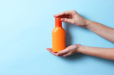 birkaç sunscreens renkli bir arka plan üzerinde eller içinde. Kozmetik güvenli güneş yanığı için.