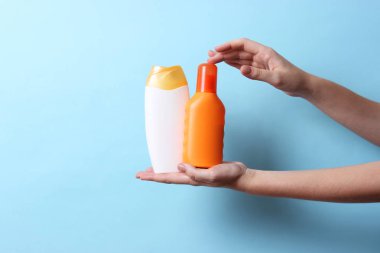 birkaç sunscreens renkli bir arka plan üzerinde eller içinde. Kozmetik güvenli güneş yanığı için.