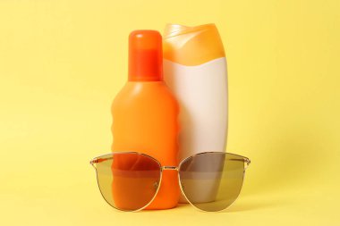 birkaç sunscreens ve renkli bir arka plan üzerinde güneş gözlüğü. Kozmetik güvenli güneş yanığı için.