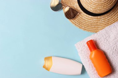 Güneş kremi, havlu, şapka, gözlük renkli bir arka plan üzerinde. Kozmetik için güvenli sunburn.top görünümü, flatlay 