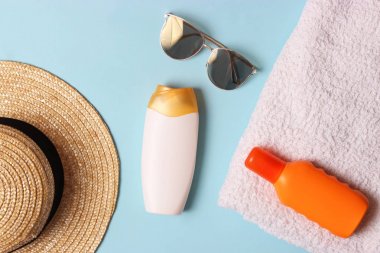 Güneş kremi, havlu, şapka, gözlük renkli bir arka plan üzerinde. Kozmetik için güvenli sunburn.top görünümü, flatlay 