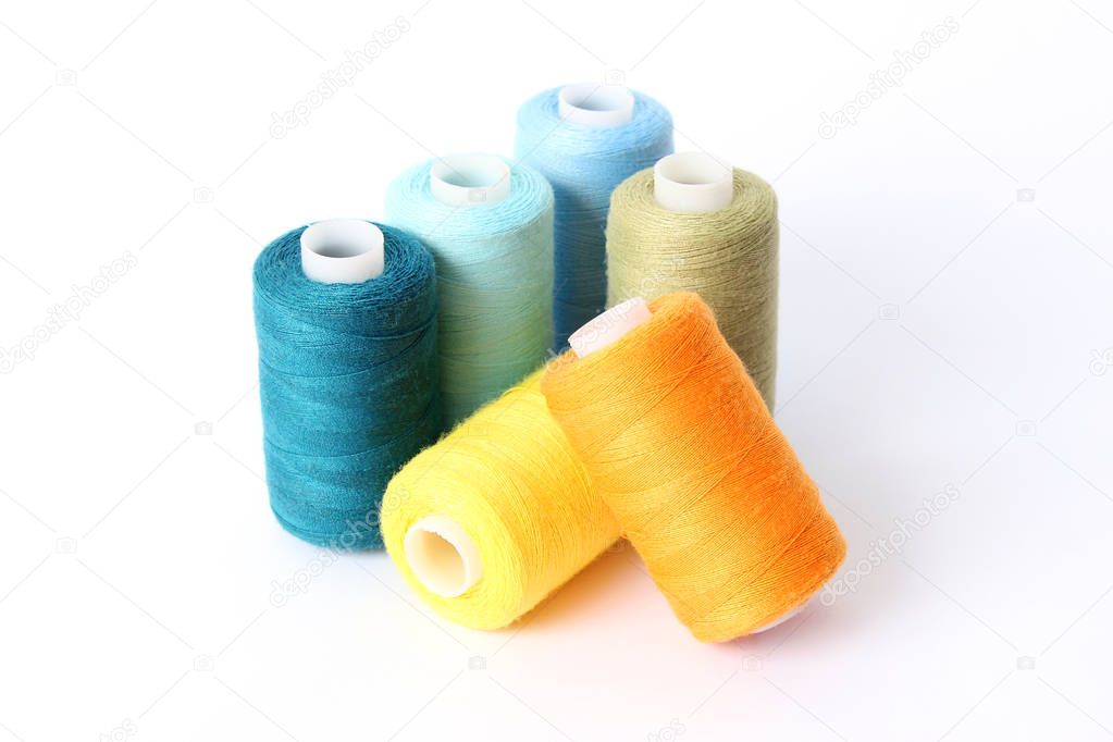 sewing thread of different colors isolated on white.