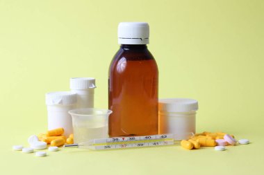 renkli bir arka plan üzerinde soğuk algınlığı tedavisi için farklı ilaçların ayarlayın. termometre, tablet, şurubu. Sağlık kavramı