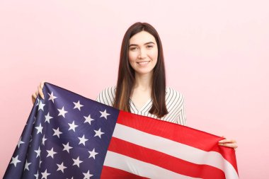Amerika bayrağını renkli bir arka planda tutan güzel bir genç kız..
