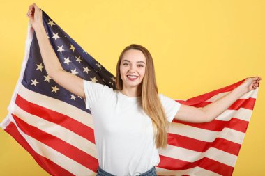 Amerika bayrağını renkli bir arka planda tutan güzel bir genç kız..