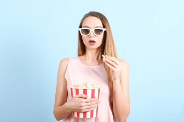 Renkli arka planda patlamış mısırı olan kız. Bir film izle, 3 boyutlu film..
