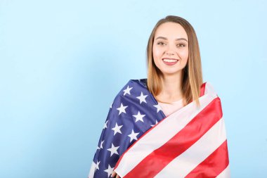 Amerika bayrağını renkli bir arka planda tutan güzel bir genç kız..