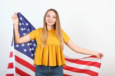 Amerika bayrağını renkli bir arka planda tutan güzel bir genç kız..