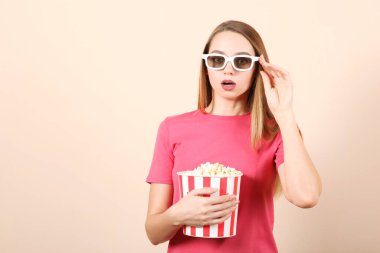 Renkli arka planda patlamış mısırı olan kız. Bir film izle, 3 boyutlu film..