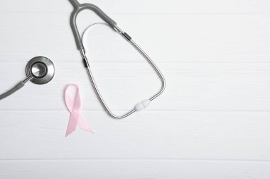 Renkli arka plan görüntüsünde pembe kurdele ve steteskop. Kanserli hastalık.