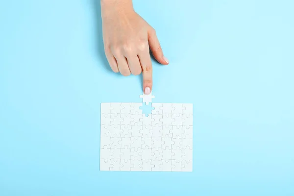 Collect puzzle. Hand and puzzle pieces on the table