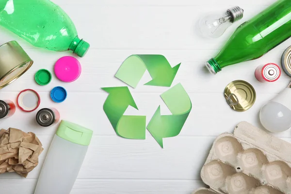 Different types of garbage and recycling sign on a colored background top view. The concept of nature conservation, separation and sorting of garbage.