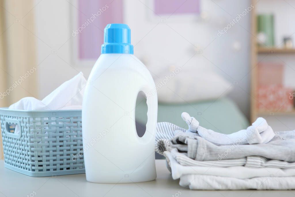 Baby clothes and detergents on the table. Baby clothes care concept.