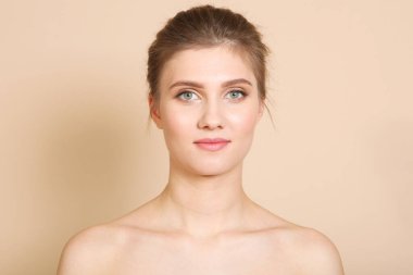 Renkli arka planda çıplak makyajlı güzel bir genç kızın portresi. Sağlıklı ve temiz ten konsepti, cilt bakımı.