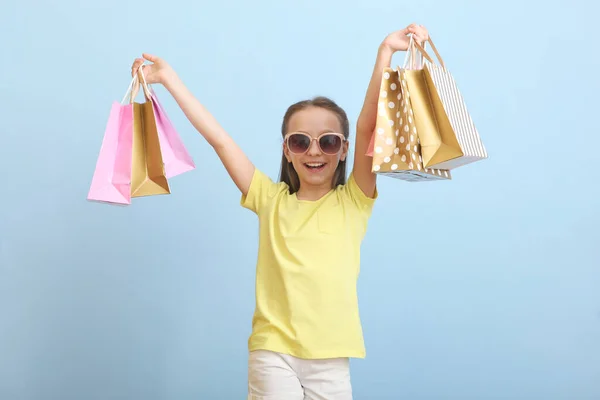 色の背景で買い物のための袋を持つ美しい笑顔の女の子 子供の買い物の概念 — ストック写真