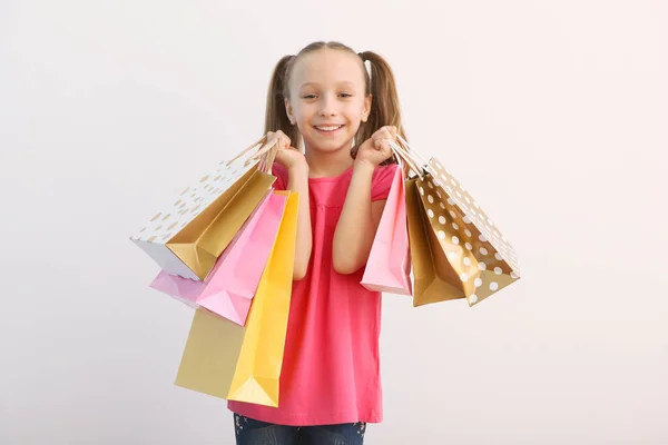 Hermosa Niña Sonriente Con Bolsas Para Compras Sobre Fondo Color —  Fotos de Stock