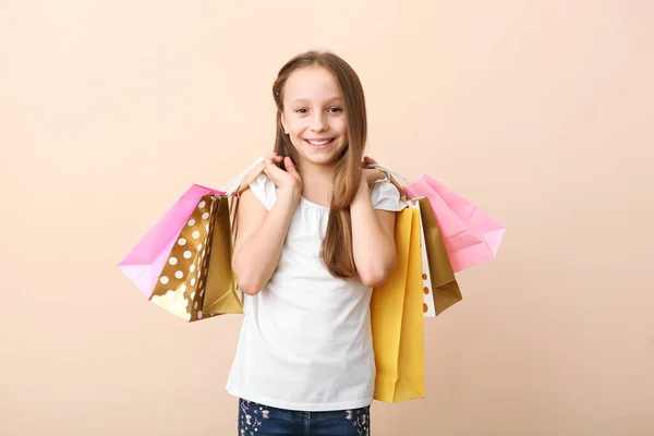 色の背景で買い物のための袋を持つ美しい笑顔の女の子 子供の買い物の概念 — ストック写真