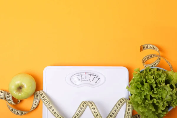 floor scales, tape measure and healthy products on a colored background top view. The concept of a healthy diet, body weight control. Healthy lifestyle.