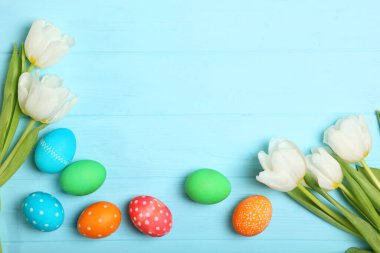 Paskalya yumurtaları ve çiçekler masanın üstünde. Metin eklemek için bir yeri olan Paskalya bileşimi.