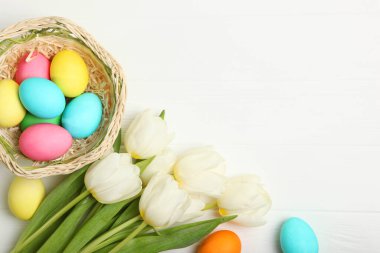 Paskalya yumurtaları ve çiçekler masanın üstünde. Metin eklemek için bir yeri olan Paskalya bileşimi.