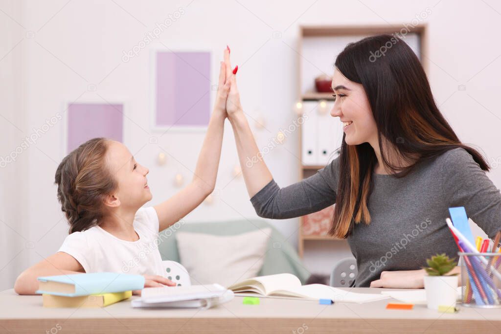 Mom helps the girl to do homework. Children and parents.
