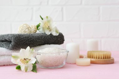 Masanın üzerinde havlular ve çiçekler olan spa kompozisyonu ve yazı için yer. Vücut bakımı, rahatlama