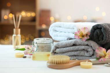 Masanın üzerinde havlular ve çiçekler olan spa kompozisyonu ve yazı için yer. Vücut bakımı, rahatlama