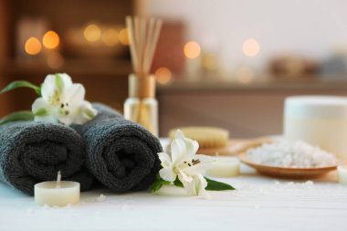 Masanın üzerinde havlular ve çiçekler olan spa kompozisyonu ve yazı için yer. Vücut bakımı, rahatlama