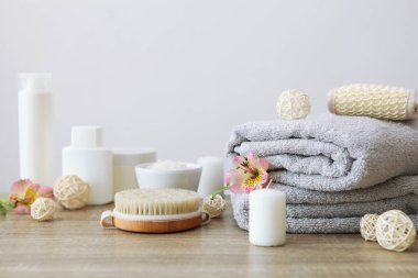 Masanın üzerinde havlular ve çiçekler olan spa kompozisyonu ve yazı için yer. Vücut bakımı, rahatlama