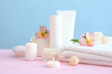 Masanın üzerinde havlular ve çiçekler olan spa kompozisyonu ve yazı için yer. Vücut bakımı, rahatlama