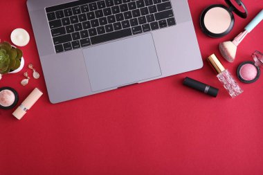 Renkli arka plan görünümlü makyaj malzemeleri ve modern laptop. Güzellik Günlüğü Konsepti