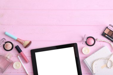 Renkli arka plan görünümlü kozmetik ve modern tablet. Güzellik günlüğü konsepti.
