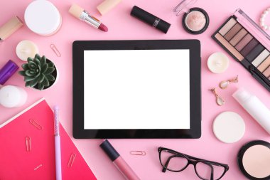 Renkli arka plan görünümlü kozmetik ve modern tablet. Güzellik günlüğü konsepti.