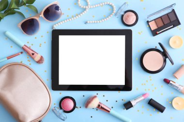 Renkli arka plan görünümlü kozmetik ve modern tablet. Güzellik günlüğü konsepti.