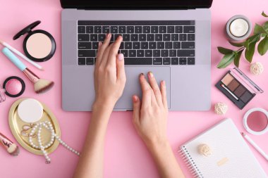 Renkli arka plan görünümlü makyaj malzemeleri ve modern laptop. Güzellik Günlüğü Konsepti