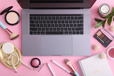 Renkli arka plan görünümlü makyaj malzemeleri ve modern laptop. Güzellik Günlüğü Konsepti