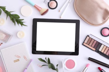 Renkli arka plan görünümlü kozmetik ve modern tablet. Güzellik günlüğü konsepti.