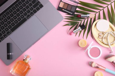 Renkli arka plan görünümlü makyaj malzemeleri ve modern laptop. Güzellik Günlüğü Konsepti