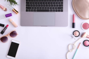 Renkli arka plan görünümlü makyaj malzemeleri ve modern laptop. Güzellik Günlüğü Konsepti