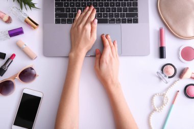 Güzellik blogu konsepti. Modern dizüstü bilgisayar ve kadın elleri, kozmetik üst görünümü yuvalama arka planında. Bağımsız, blog, internet, gönderi.