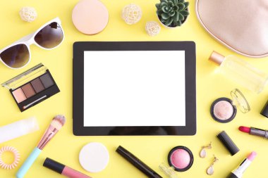 Renkli arka plan görünümlü kozmetik ve modern tablet. Güzellik günlüğü konsepti.