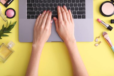 Güzellik blogu konsepti. Modern dizüstü bilgisayar ve kadın elleri, kozmetik üst görünümü yuvalama arka planında. Bağımsız, blog, internet, gönderi.