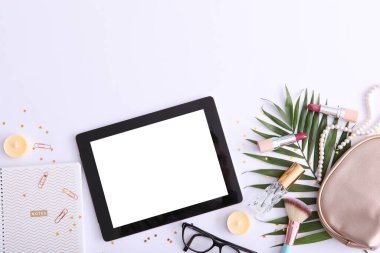 Renkli arka plan görünümlü kozmetik ve modern tablet. Güzellik günlüğü konsepti.